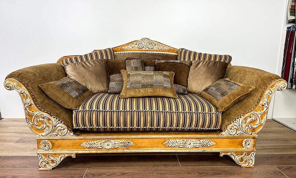 Элегантный классический диван с резным деревянным основанием золотистого цвета, обитый мягкой тканью в теплых коричневых тонах после перетяжки